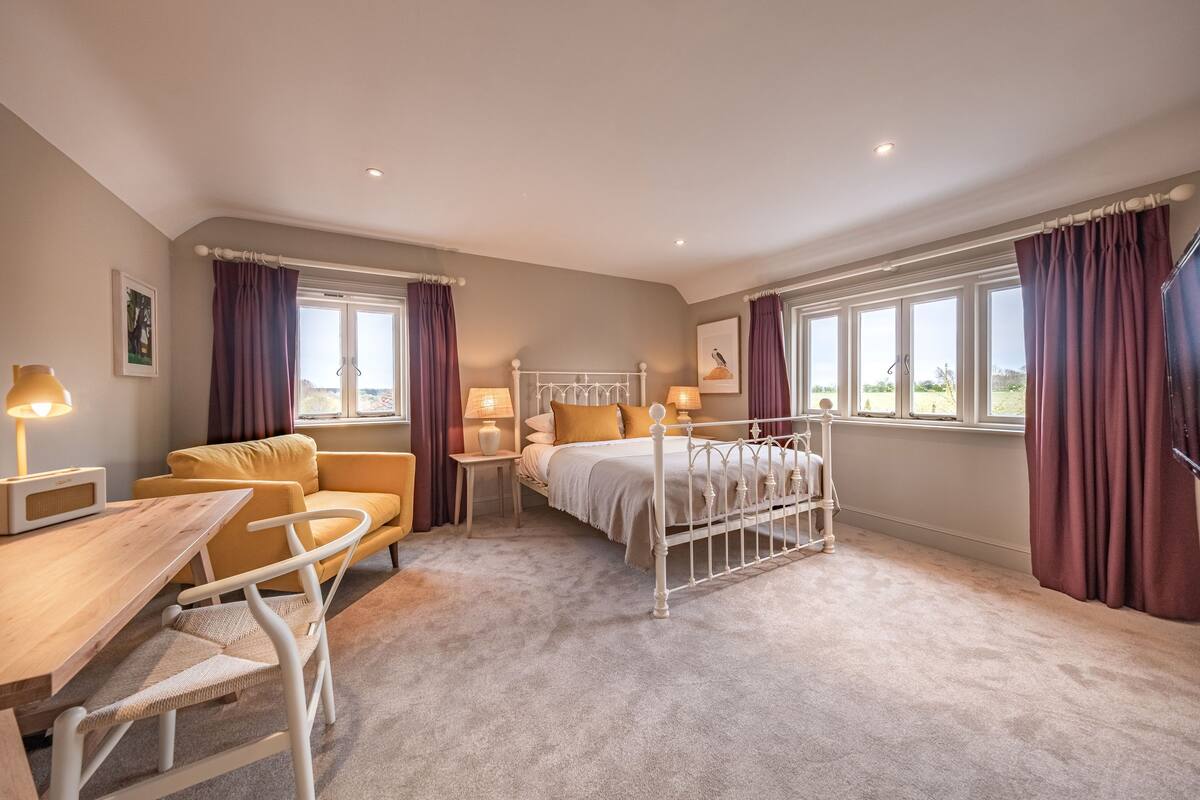 Een slaapkamer met een bed, een slaapbank, een tafel en een stoel.