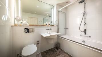 A modern bathroom with a toilet, sink, and shower.