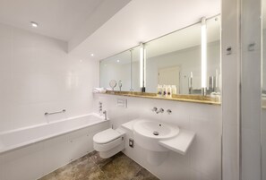 Un baño moderno con bañera, inodoro y lavamanos.