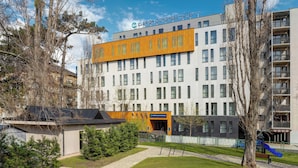 Un hotel moderno con un cartel llamativo, varios pisos y una combinación de estilos arquitectónicos.