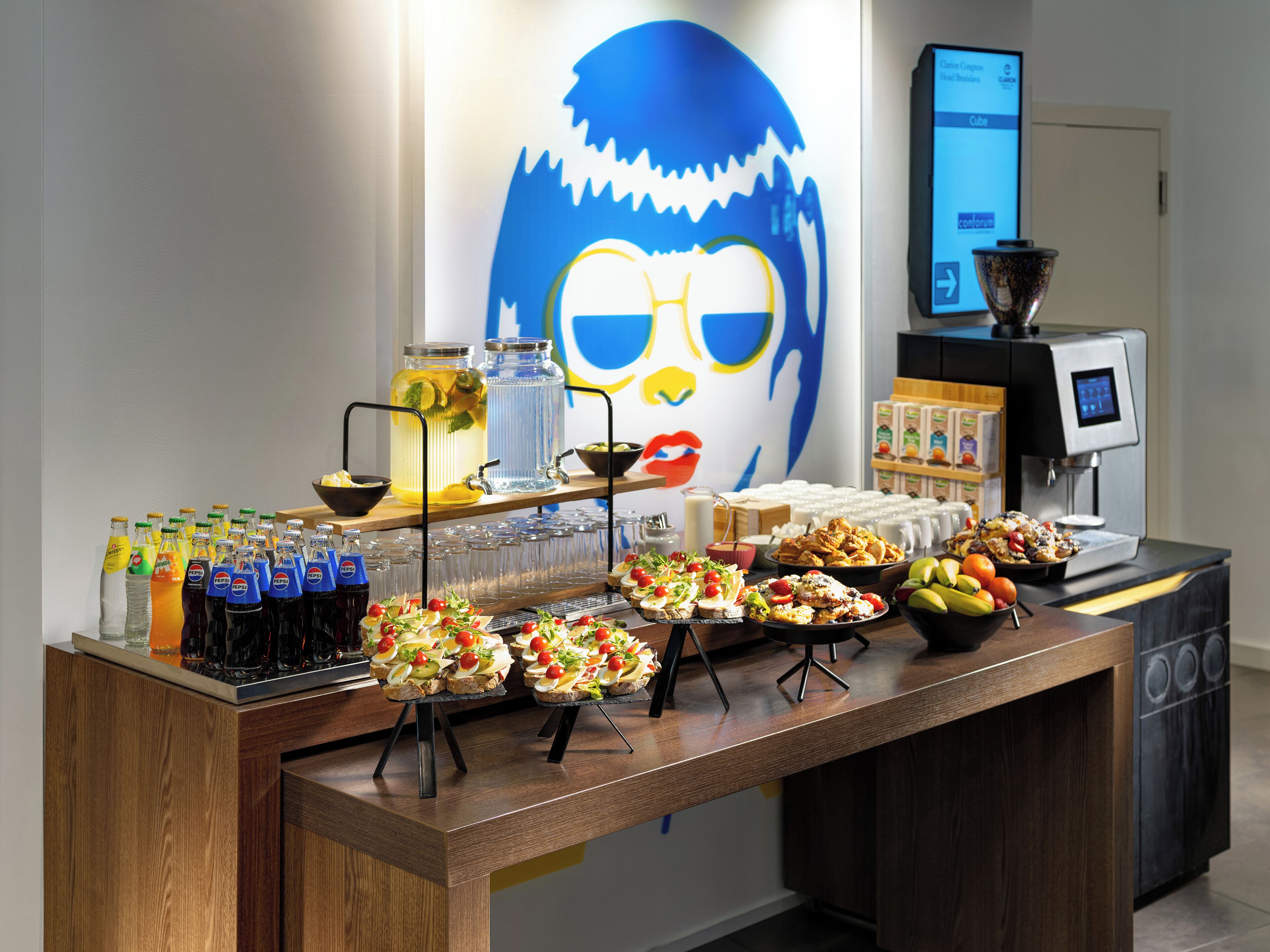 Ein Buffet mit verschiedenen Speisen, Getränken und einer Kaffeemaschine.