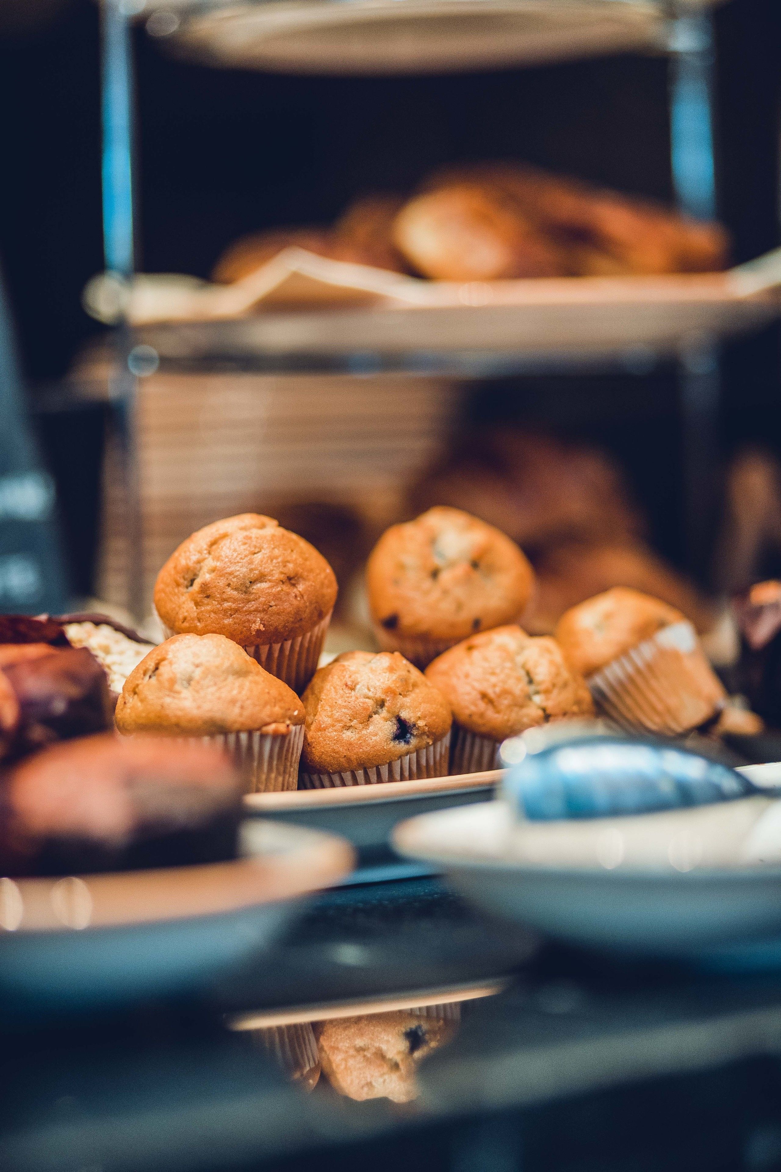 Una bandeja de muffins y pasteles sobre una mesa.