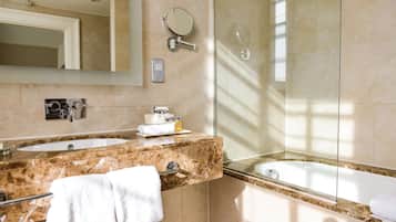 A modern bathroom with two sinks, a large mirror, a towel rack, and a shower.