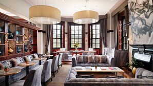A spacious lobby with a sofa, chairs, a coffee table, and a dining area. - The Grand, York (York)