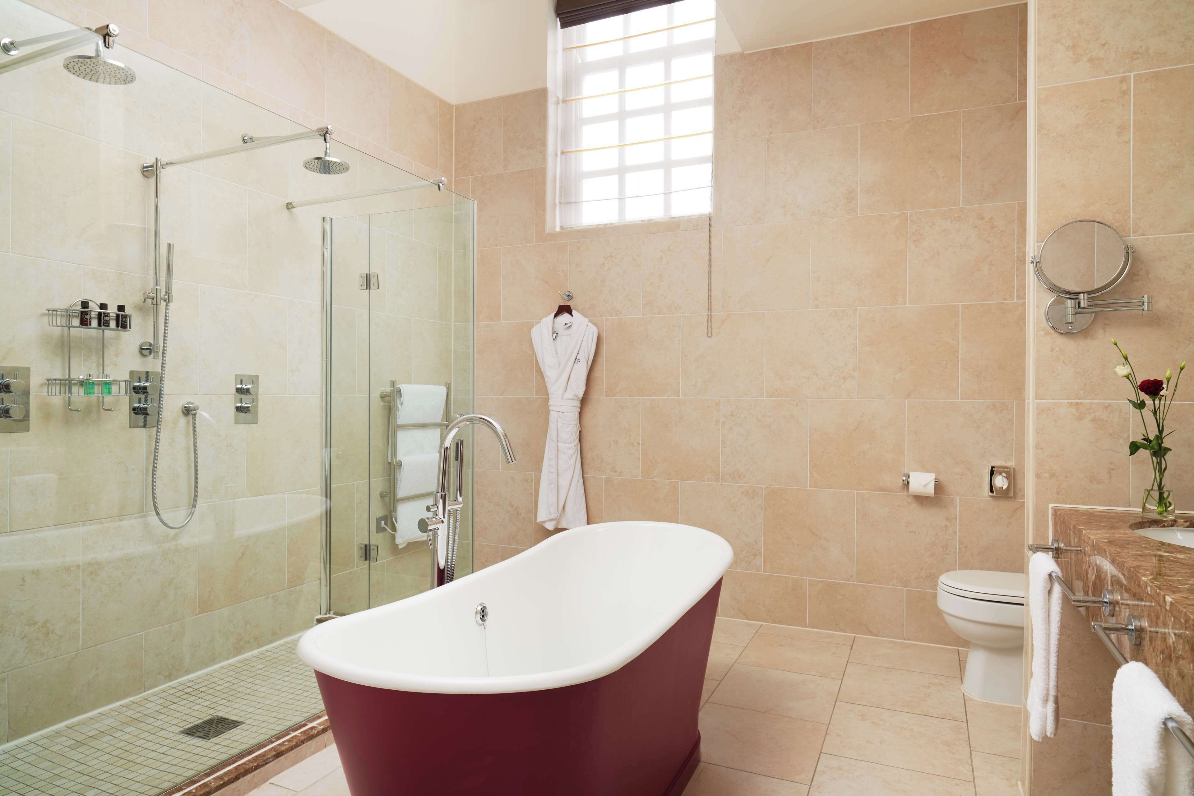 A modern bathroom with a glass-enclosed shower, a freestanding bathtub, and a toilet.