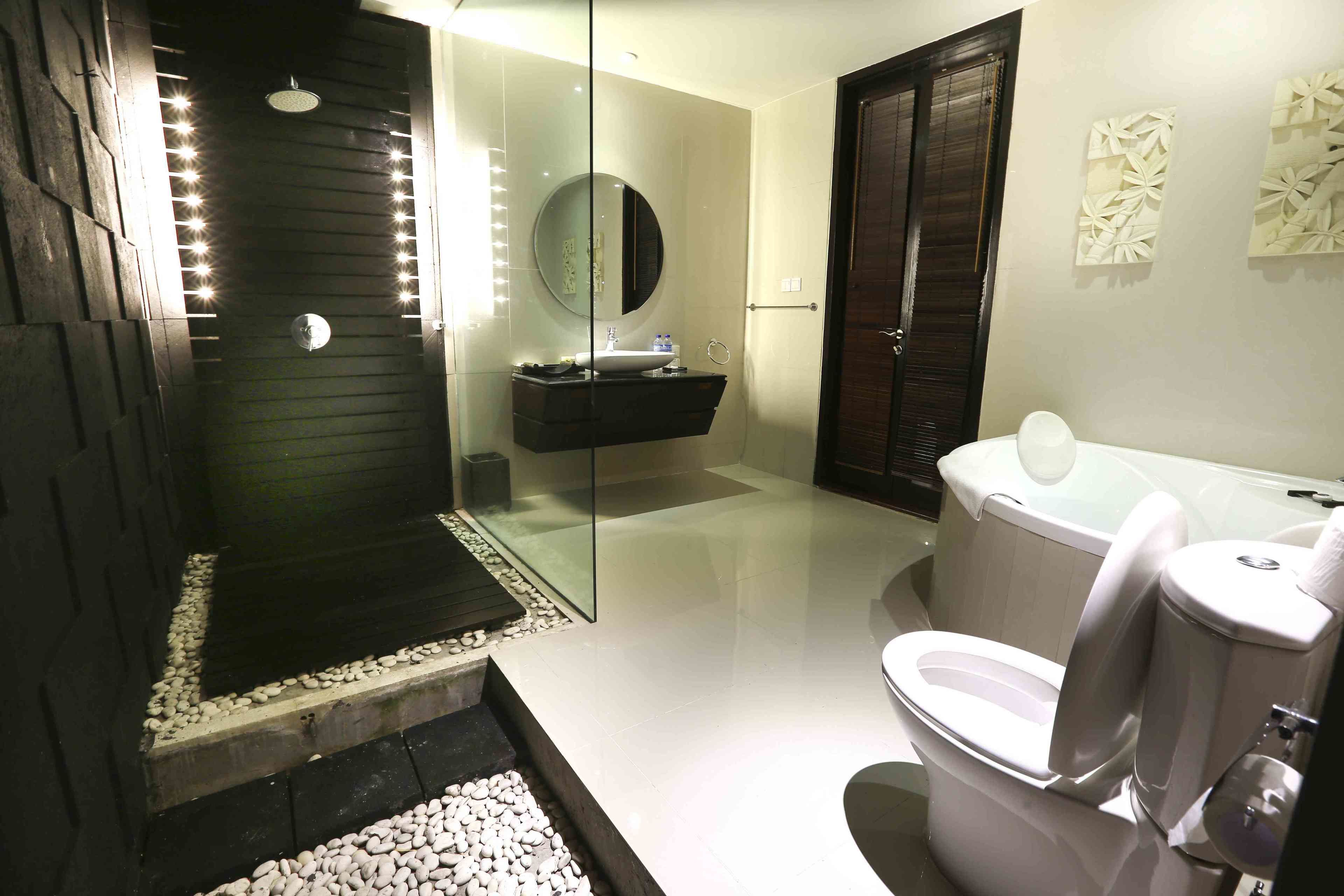 A modern bathroom with a glass-enclosed shower, a freestanding bathtub, and a toilet.