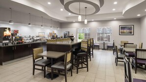 Um restaurante moderno com balcão central, mesas e cadeiras para refeições.