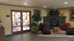 Eine Hotelhalle mit Essbereich, Kamin und Fernseher.