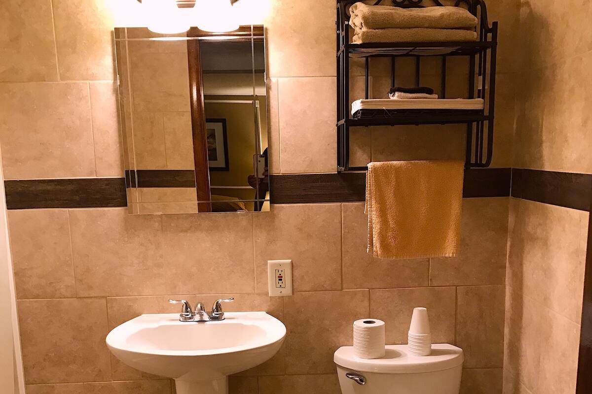 A bathroom with a sink, toilet, and a towel rack.