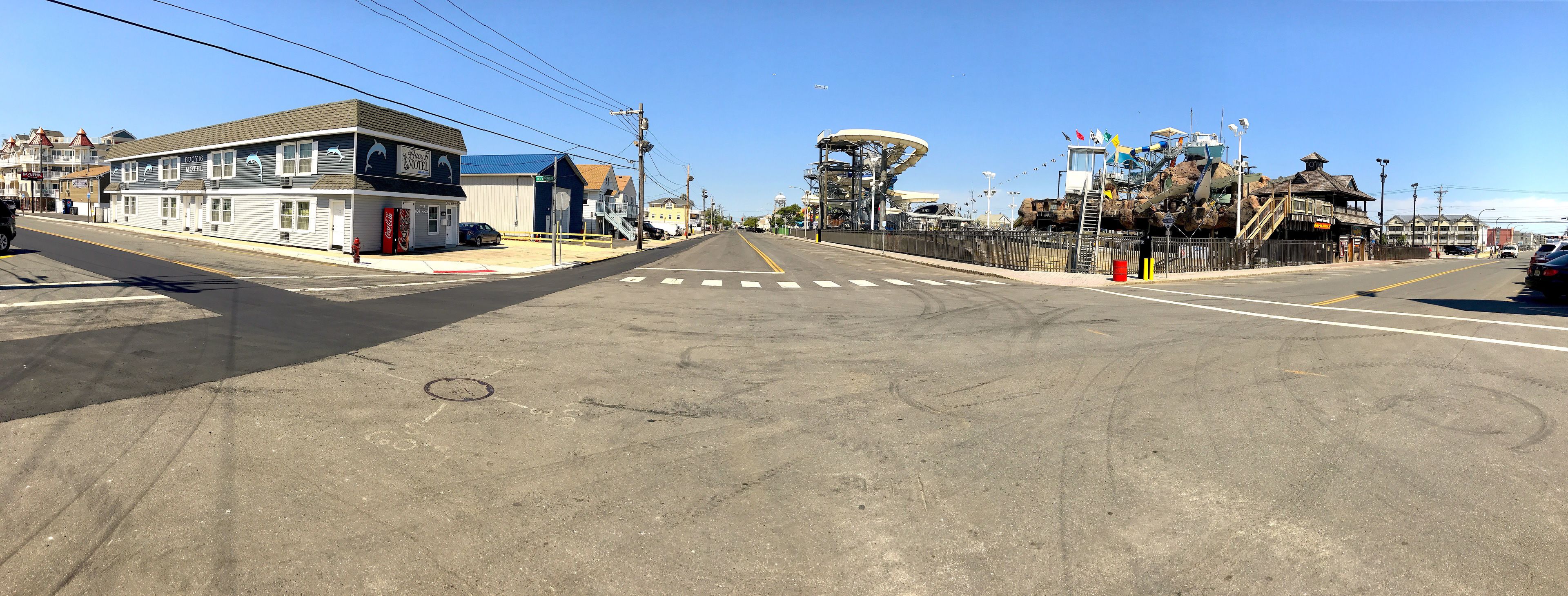 Une vue de rue avec un motel, un grand bâtiment doté d’une plateforme d’observation et un ciel dégagé.