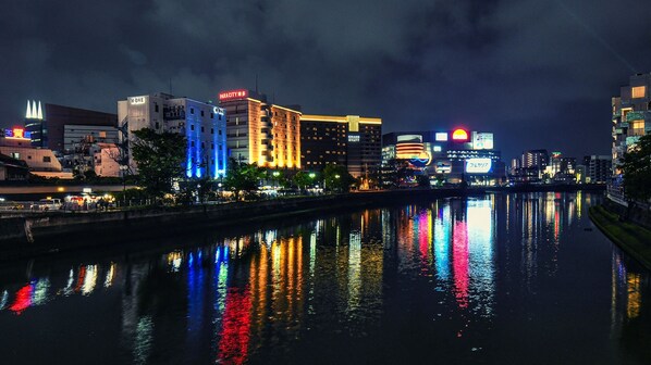 A cityscape at night with illuminated buildings reflecting on the water. - Vessel Inn Hakata Nakasu (Fukuoka)