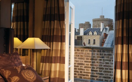 A hotel room with a view of a historic castle.