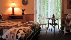 Une chambre à coucher avec un lit, une table et des chaises, une lampe et une fenêtre avec des stores.