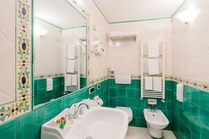 Un baño con lavamanos, bidé y espejo.
