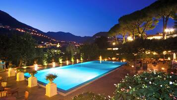 Una piscina al aire libre de temporada, sillones reclinables de piscina