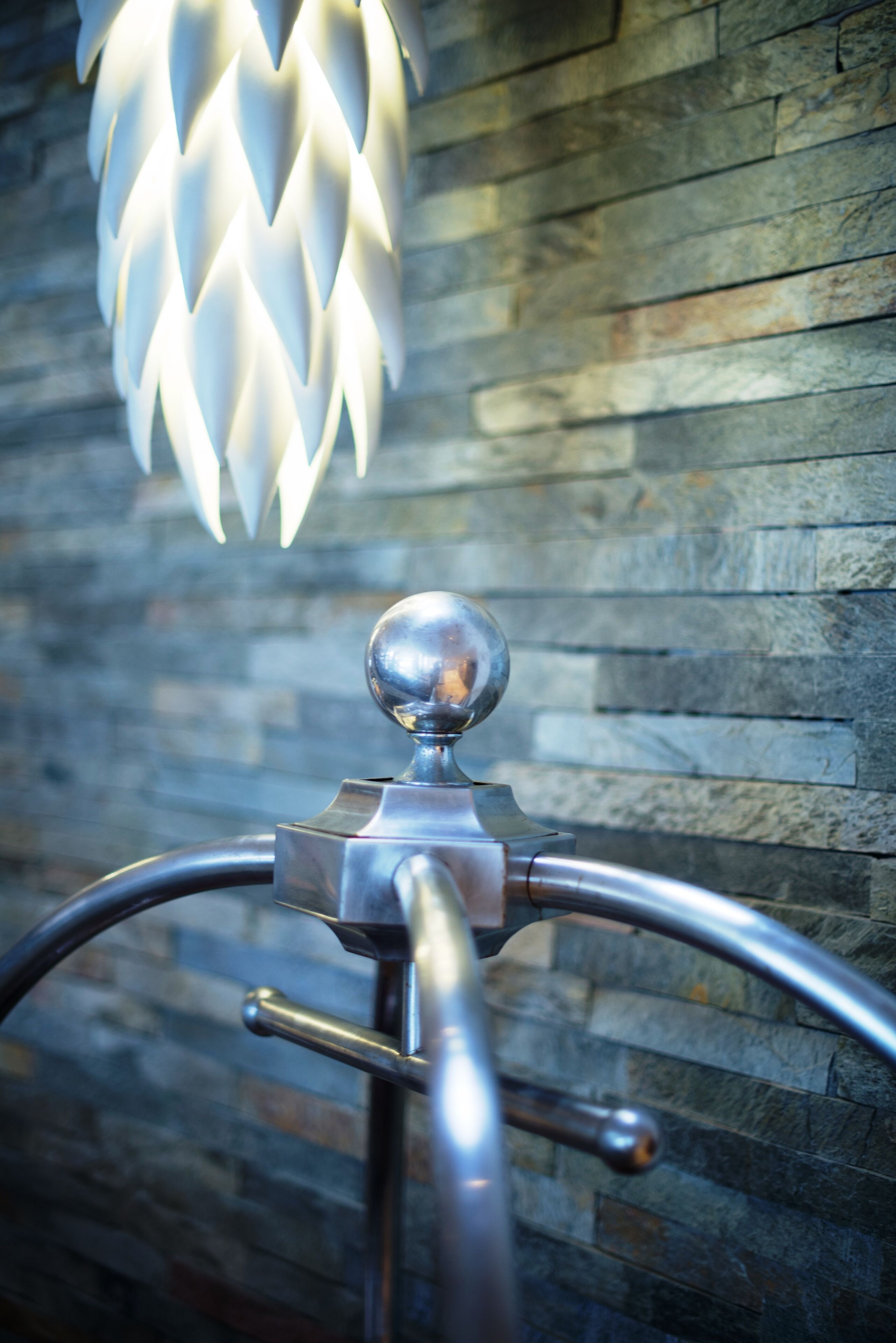 Een metalen constructie met een bolle bovenkant en een gebogen handgreep voor een stenen muur.