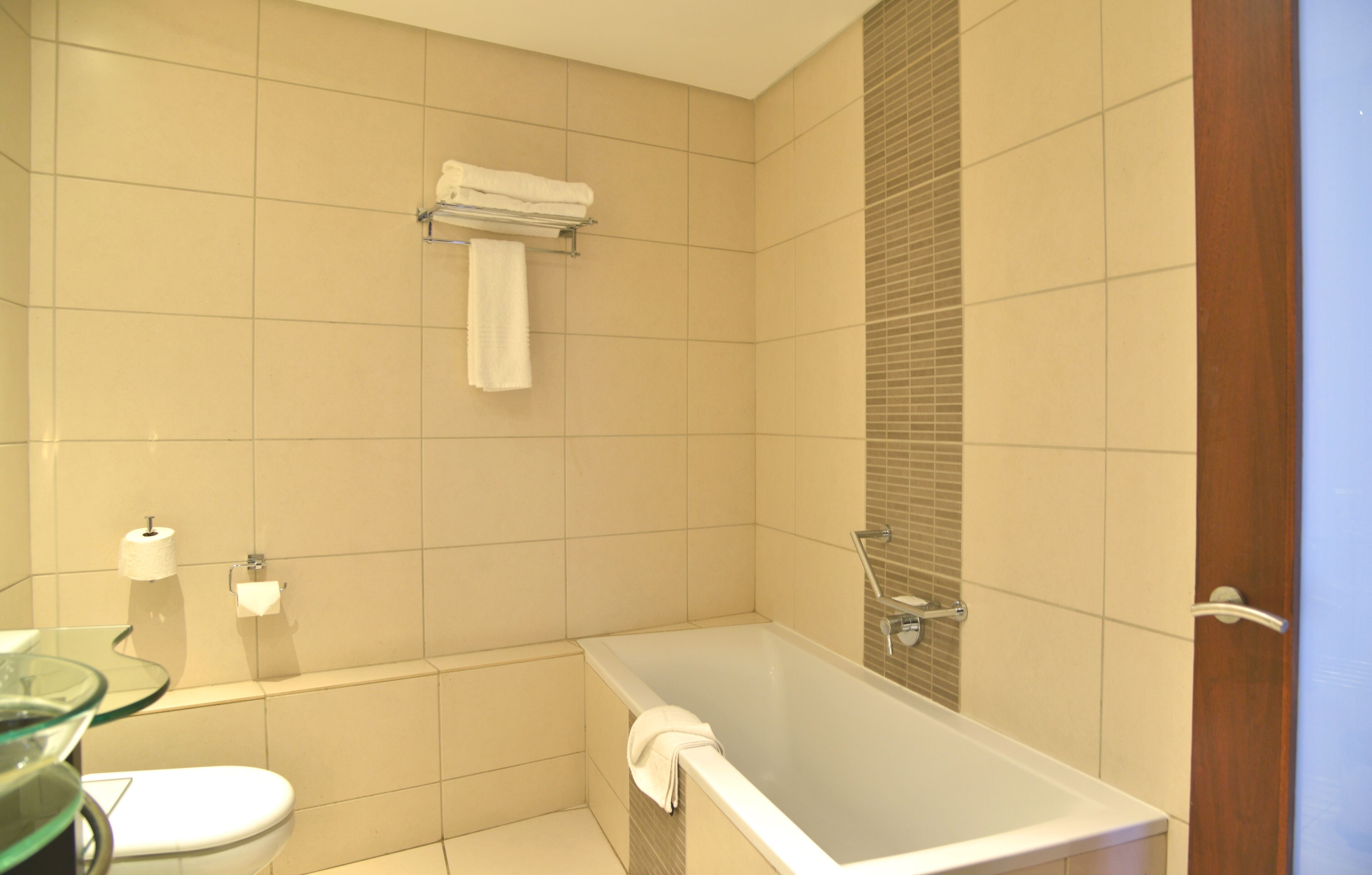 Un baño con bañera, inodoro y cabina de ducha de vidrio.