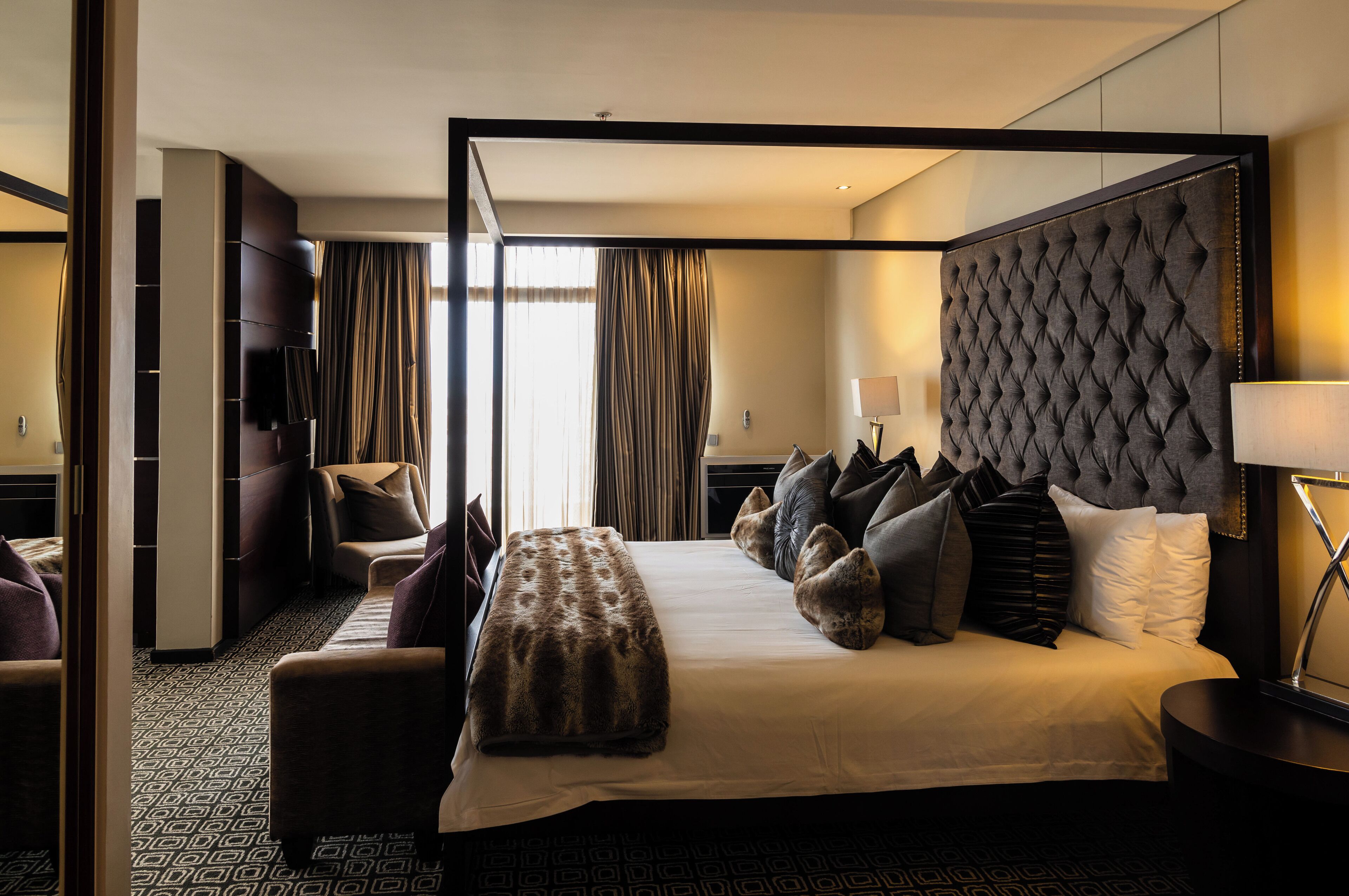 Une chambre d’hôtel dotée d’un grand lit, d’un coin salon, d’une télévision et offrant une vue sur l’extérieur.