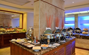 A buffet setup with various food items and beverages.