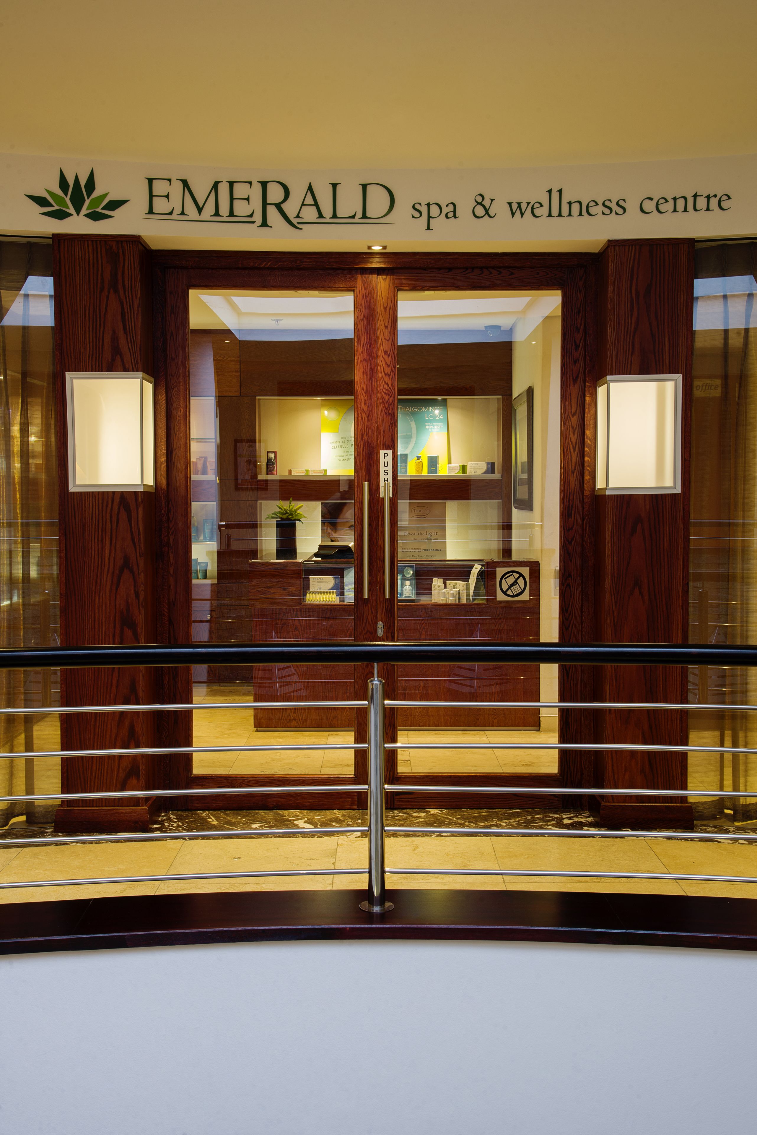 The entrance to the Emerald Spa & Wellness Centre with a wooden facade and glass doors.