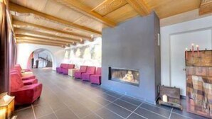 Un lobby moderno con chimenea, zona de estar y vistas al exterior.