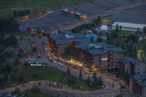 Un hotel amb un edifici central, una zona d'aparcament i un hivernacle.
