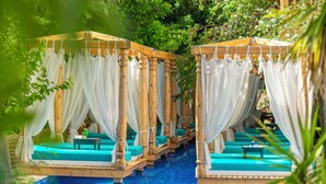 A poolside area with wooden cabanas and blue lounge chairs. - Elixir Boutique Hotel (Kalkan)