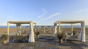 A beachside deck with wooden flooring, outdoor seating, and umbrellas. - Adriatic Palace Hotel (Jesolo)