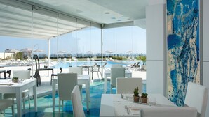 A rooftop pool area with clear views of the city skyline, modern outdoor seating, and a large abstract painting. - Adriatic Palace Hotel (Jesolo)