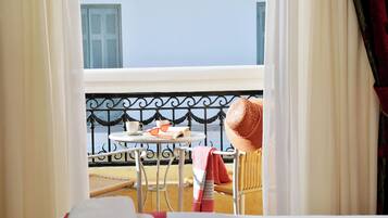 A balcony with a table, chairs, and a wicker chair.