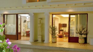 A hotel entrance with columns, a reception area, and potted plants. - Hotel Agistri (Agistri)