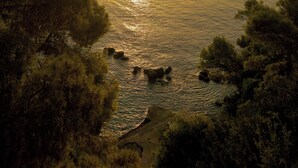 A coastal landscape with a sunset over the sea, surrounded by trees. - Hotel Agistri (Agistri)