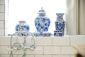 A bathroom with a window sill displaying various blue and white ceramic vases. - Les Nuits Hotel (Antwerp)