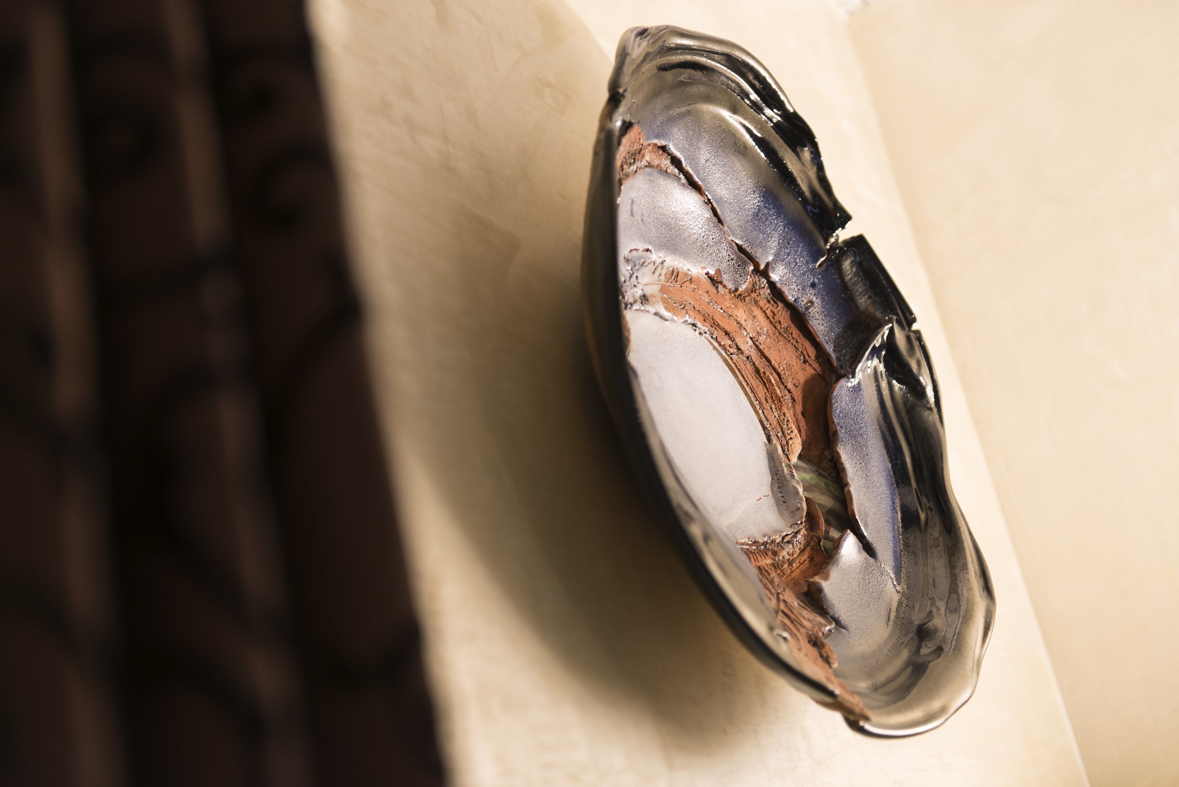 A close-up of a damaged glass object, possibly a decorative item, with visible cracks and broken pieces.