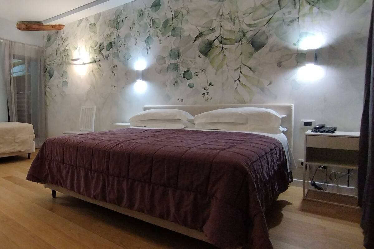 A bedroom with a bed, bedside tables, a chair, and a desk.