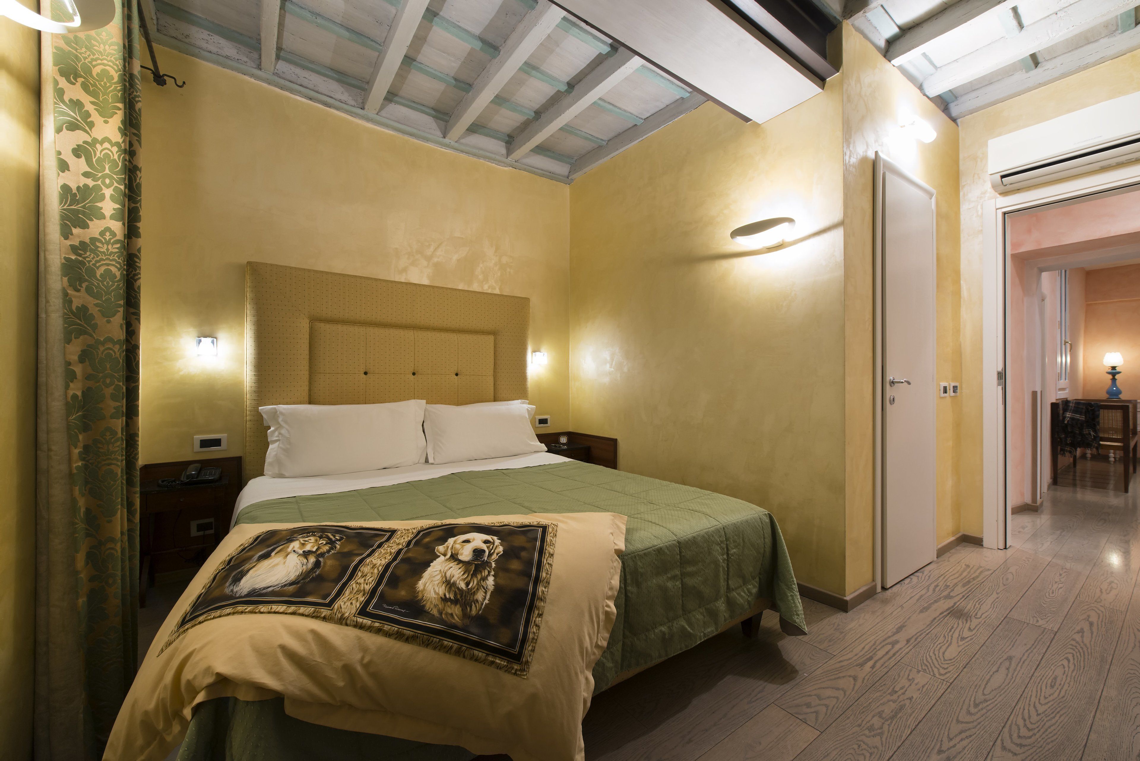 Ein Hotelzimmer mit Bett, Nachttisch und Wandleuchte.