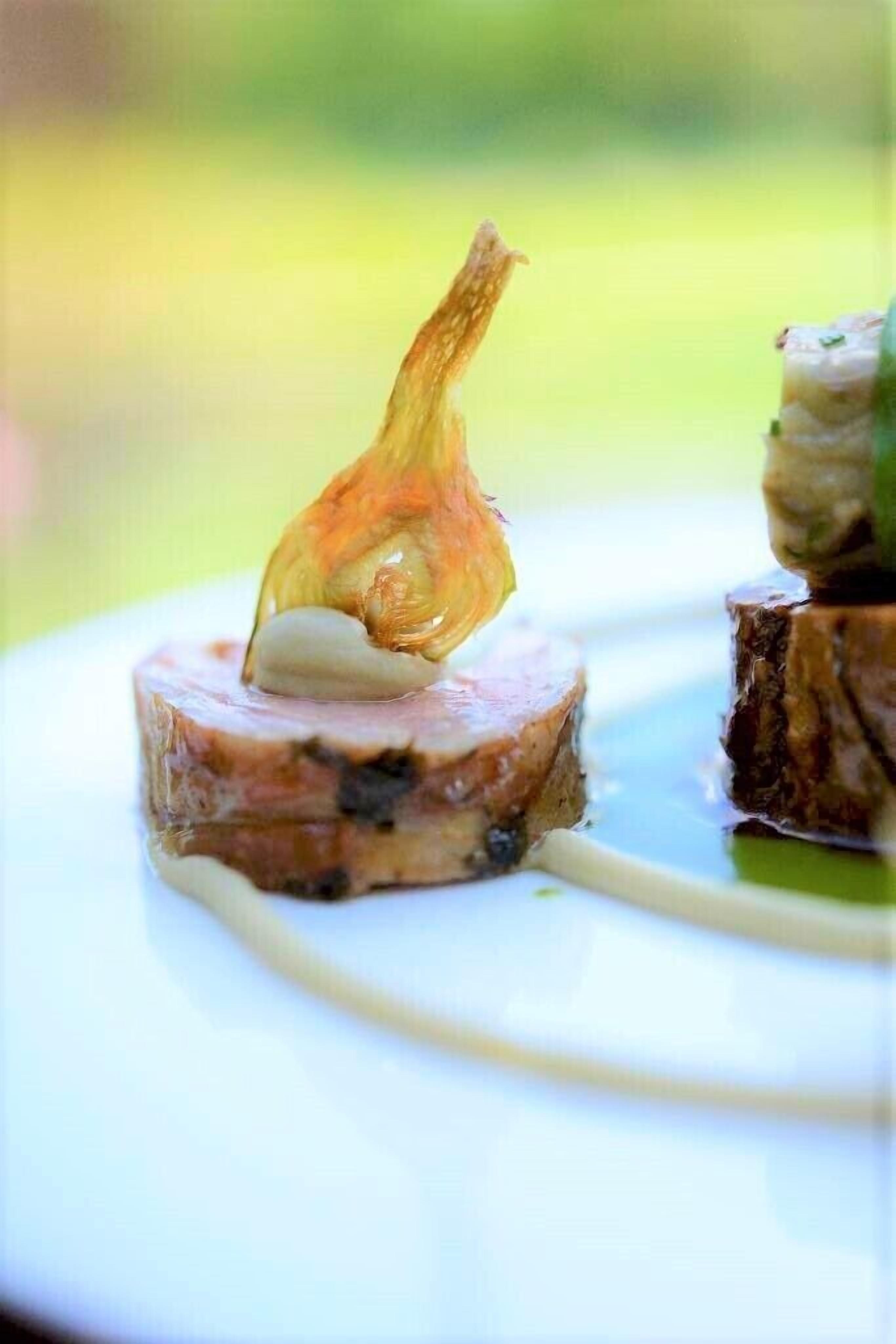 A plate with a piece of meat and a decorative element.