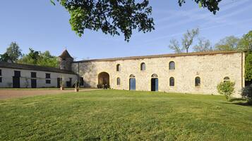 Un bâtiment historique en pierre, doté d’une cour intérieure, de portes en arc de cercle et d’une tour.