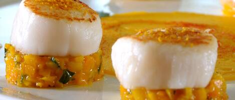 A plate with seared scallops and a mango salsa.