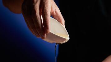 En person som häller en vätska på en annan persons hand.