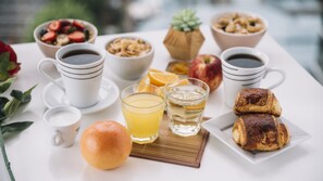 Une table dressée pour le petit-déjeuner, avec différents aliments et boissons.