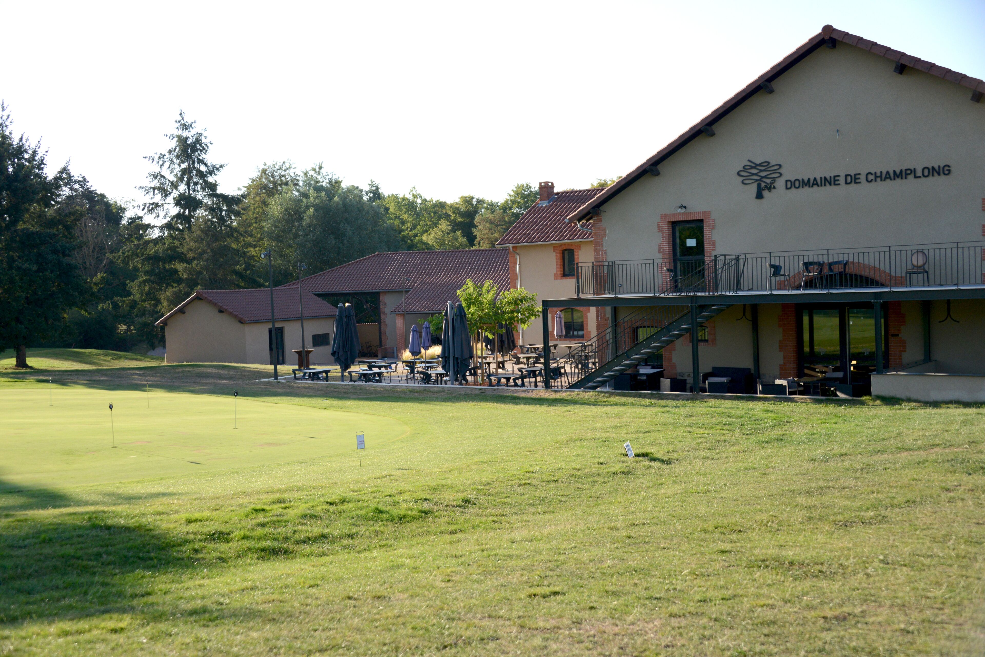 Un campo de golf con un club house llamado Domaine de Champolong.