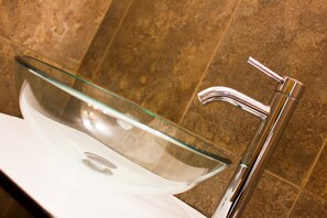 A modern bathroom with a glass vessel sink and a chrome faucet. - Charlies Place Hotel & Spa (Bogotá)