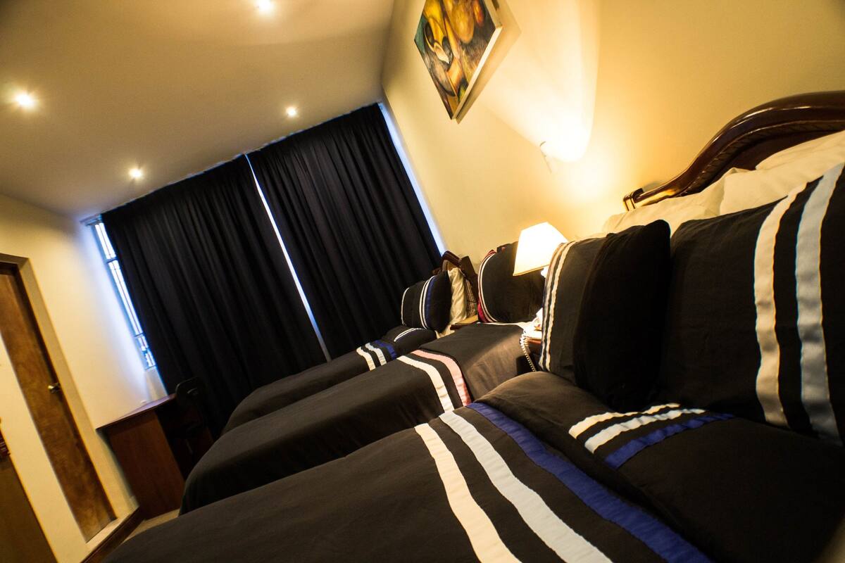 Ein Hotelzimmer mit einem großen Bett, einem Schreibtisch und einem fenster mit Vorhängen.