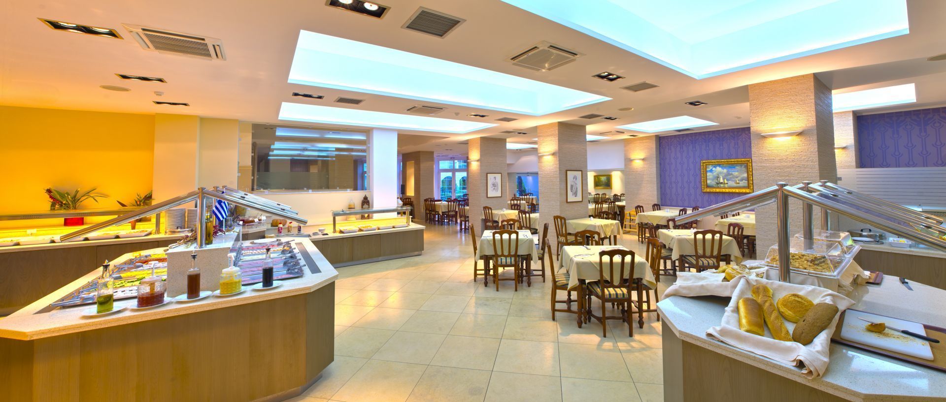 A buffet area with multiple serving counters, tables, and chairs.