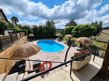 Una piscina al aire libre de temporada, sombrillas. Hôtel Belle Vue