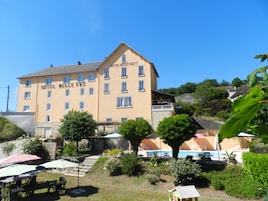 Un hotel de varios pisos con un letrero que dice "HOTEL BELLE VUE".