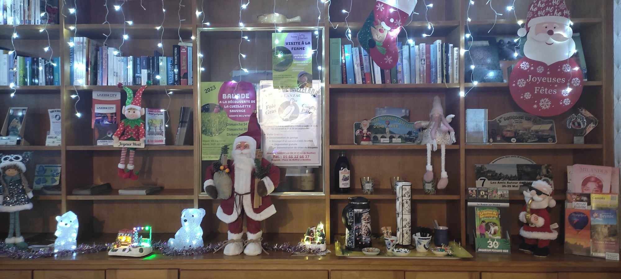 A bookstore with shelves of books, Christmas decorations, and a Santa Claus figure.