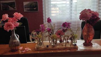 A wooden desk with multiple vases containing flowers.