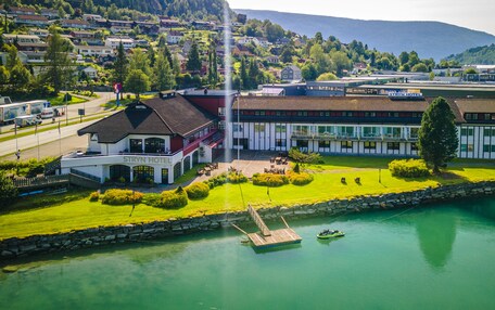 A hotel with a pool, a dock, and a view of the surrounding town and mountains.